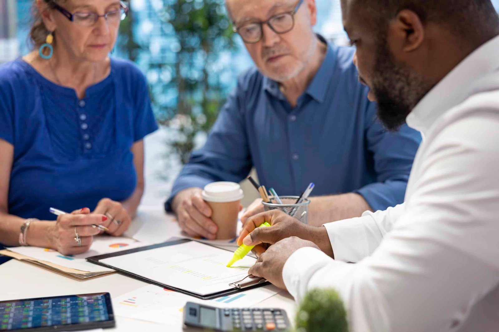 Insurance broker highlighting the important contract terms, discussing with senior couple about a new retirement plan to secure pension and finances in the future. Advisory counseling.